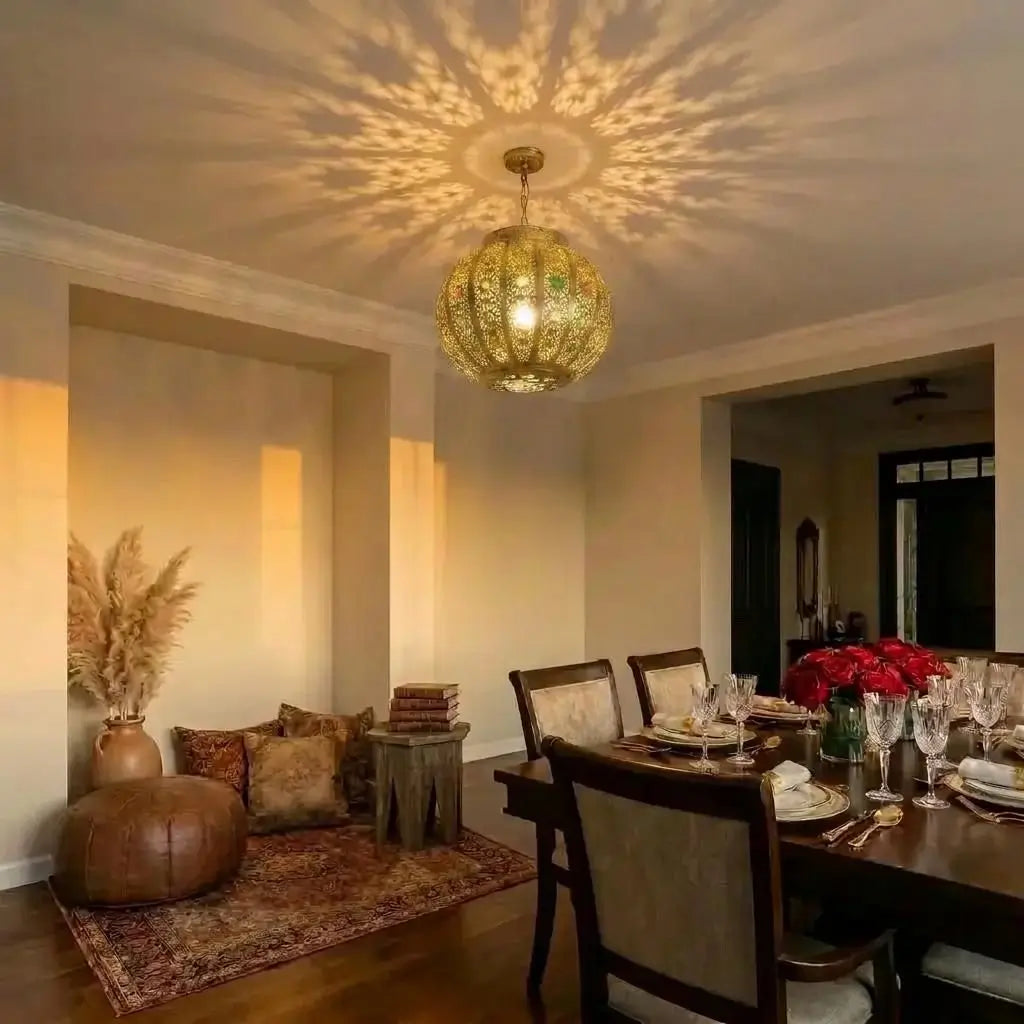 Moroccan style brass ceiling light fixture illuminating a combined dining area and a bohemian floor seating corner, casting intricate geometric shadows on the ceiling.