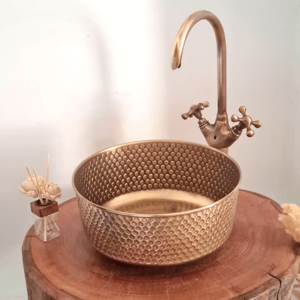 Mid-century modern hammered brushed brass sink with stylish faucet on wooden table.