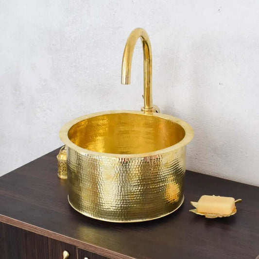 Handmade brass sink with a hammered finish, perfect for bathroom design and decor.