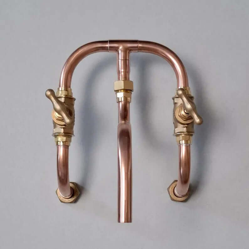 Handmade copper wall mount faucet with solid brass valves, showcasing industrial design for kitchen or bathroom.