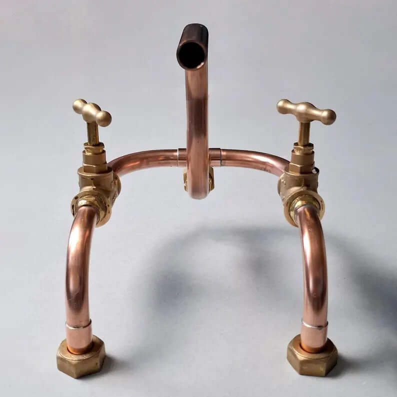 Handmade copper wall mount faucet with solid brass valves, showcasing an industrial artisan design for kitchen or bathroom.
