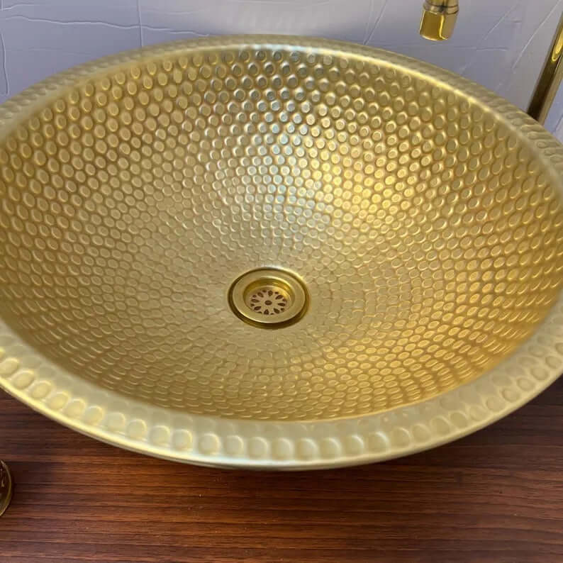 Handmade brass sink with a hammered finish, showcasing elegant texture perfect for bathroom or kitchen decor.