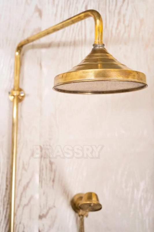 Unlacquered brass shower head with vintage design, featuring a rounded shape and elegant finish for luxury bathrooms.