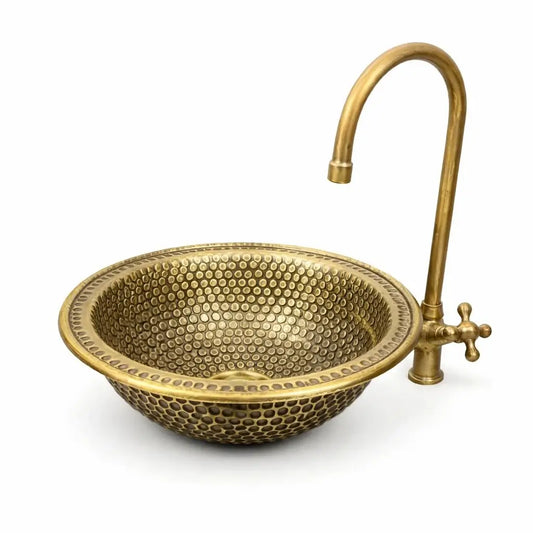 Front view of a custom handmade brass vessel sink showing color contrast between the inside and outside.