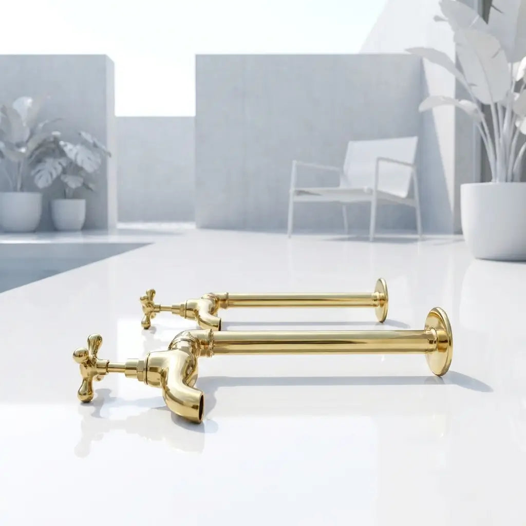 Full product display of two polished brass water filter cold taps with elegant cross handles lying on a clean white surface in a minimalist interior setting.