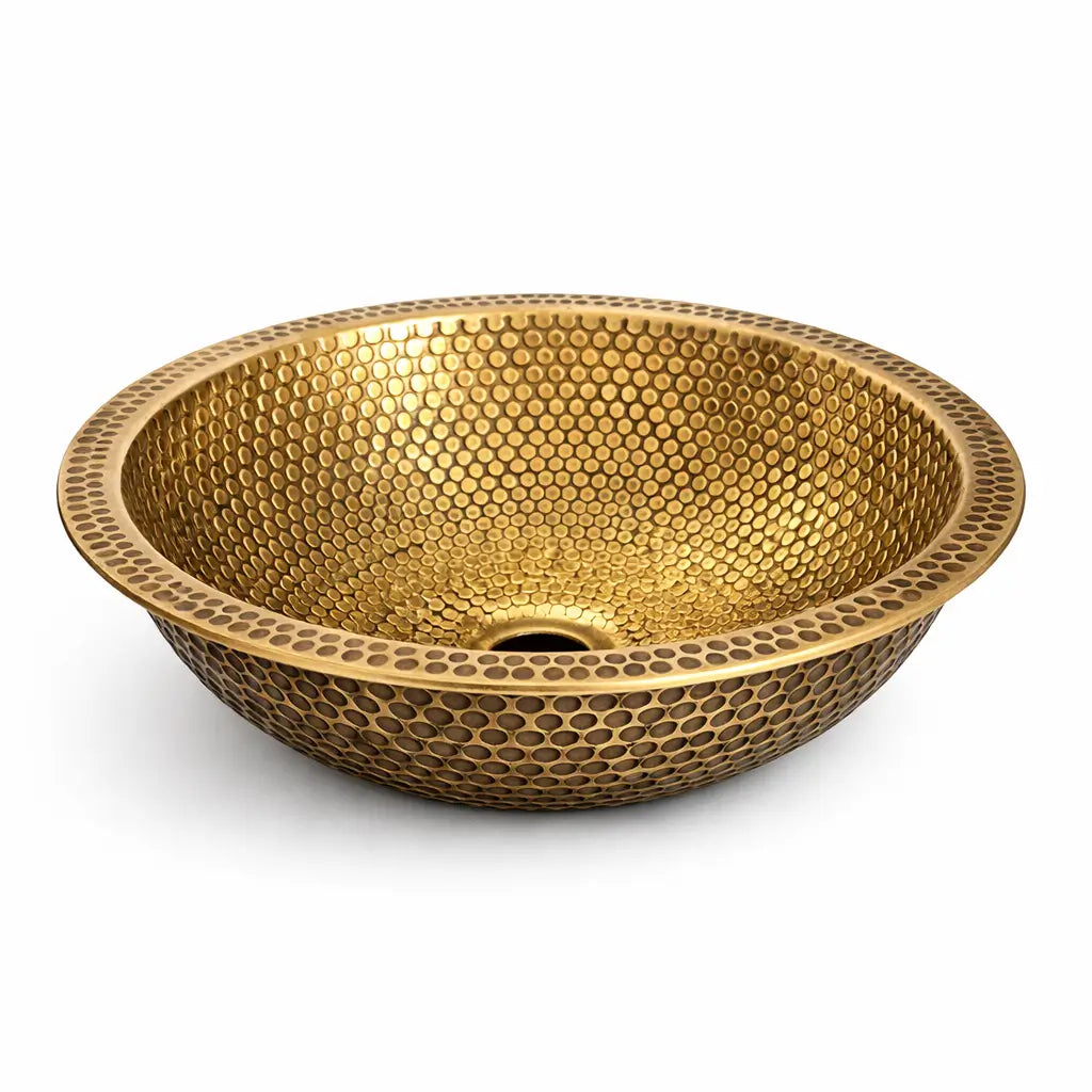 Modern custom made brushed brass bathroom sink with a round drop-in vessel design, showcasing an intricate handcrafted honeycomb hammered pattern on a seamless white background.