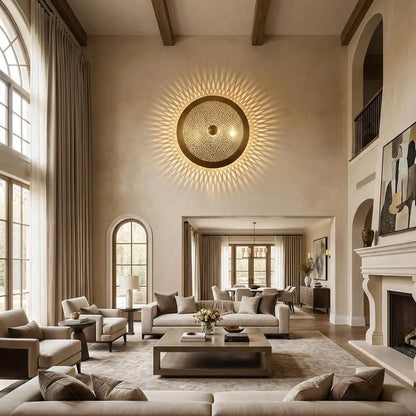 Moroccan wall light with handmade artisan brass lighting mounted high on a neutral wall in a large, luxury living room with high ceilings and tall windows.