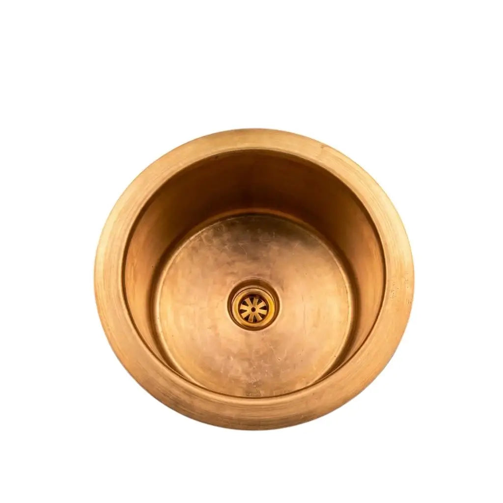 Top view of a handcrafted round brass luxury sink with a central drain grid, isolated on a clean white background for e-commerce.