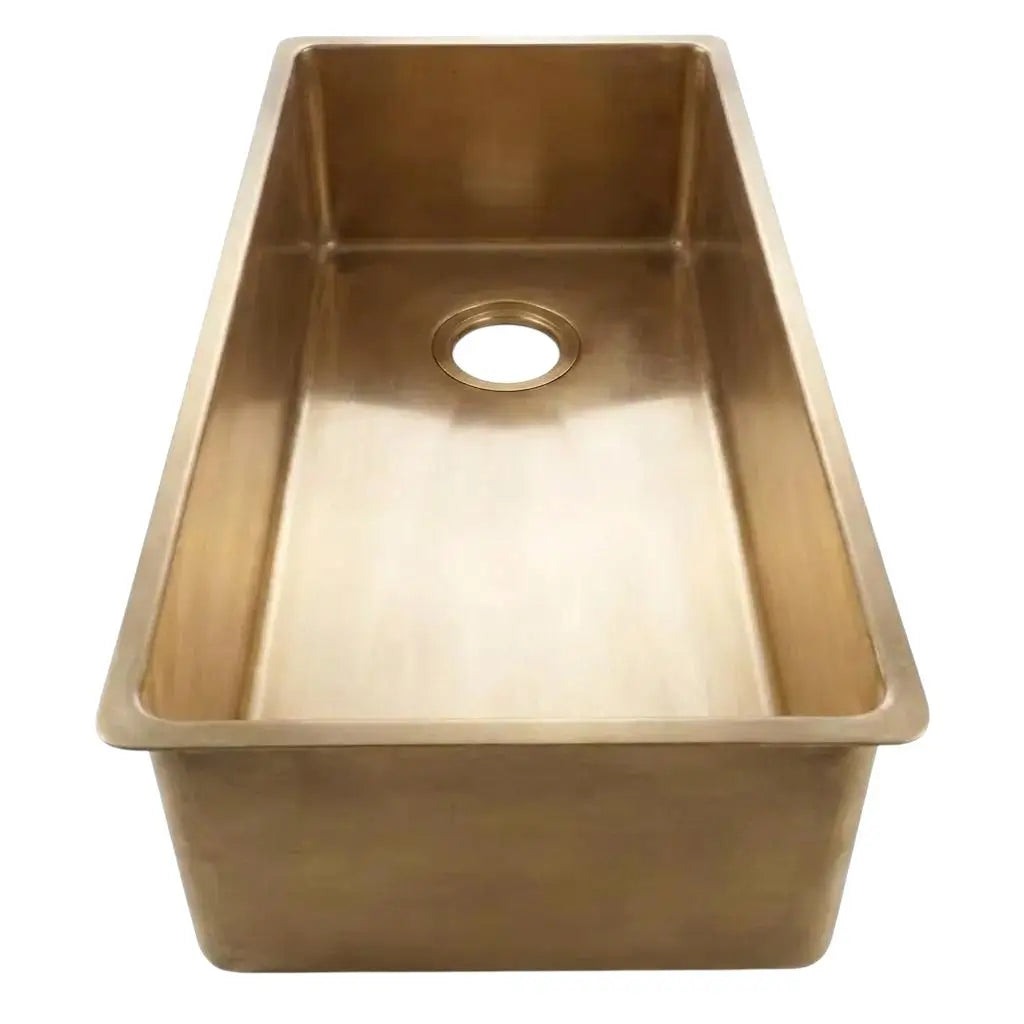 Top view of a single bowl brass kitchen sink with a clean metallic finish on a plain white background